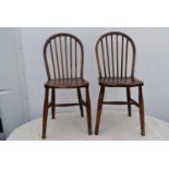 A pair of elm stick back dining chairs.