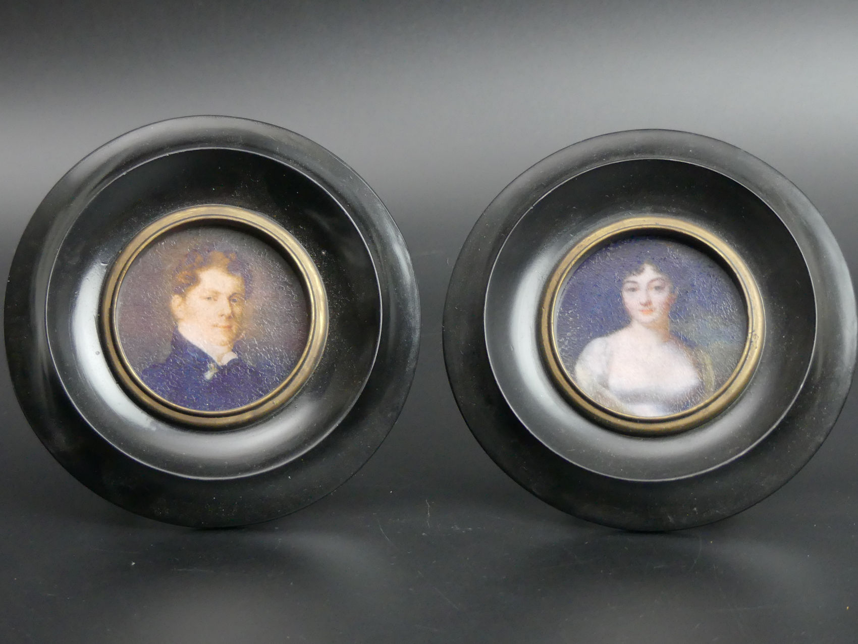 Two ebony framed portrait miniatures. 13 cm diameter. UK Postage £15.