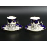 A pair of Coalport silver mounted cabinet cups and saucers. Chester 1911. Cup 6.8 cm high. Saucer 12