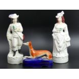 A pair of Victorian Staffordshire pottery figures and a Staffordshire pottery greyhound inkwell.