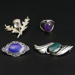 Three silver and stone set brooches, along with an amethyst set ring. 23.4 grams. Widest brooch 50