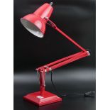 A red as new, angle-poise type table or desk lamp. UK Postage £20.