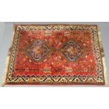 A rich red ground medallion design Persian rug. 115 cm x 150 cm. UK Postage £30.