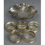 Elizabeth II pierced silver bon bon dish, Birmingham 1973 and five silver napkin rings. 153 grams.