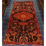 Rich red ground Iranian village, medallion and floral motif design rug. 268 cm x 115 cm. UK