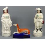 A pair of Victorian Staffordshire pottery figures and a Staffordshire pottery greyhound inkwell.