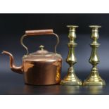 A Victorian copper kettle and a pair of brass candlesticks, complete with their pushers.