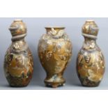 A garniture of three Japanese Meiji period Satsuma pottery vases, signatures to the bases and in the
