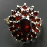 9 carat gold garnet cluster ring, Birmingham 1970. 3.5 grams. Size K Top 16.7 mm Band 2 mm. UK