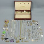 A jewellery box and contents, including a silver charm bracelet, rings, brooches and costume