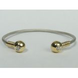 Yellow and white metal diamond set torque bangle, (Approx .5ct total), 30 grams. Ends 10.5 mm bar