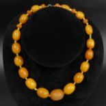 A vintage butterscotch amber egg yolk bead necklace, 37 grams. 41 cm long, largest bead 22 mm. UK
