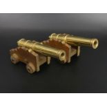 A pair of brass and wood model cannons. 16 cm long. UK Postage £15.