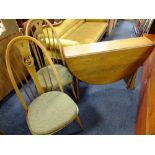 AN ERCOL WINSOR DROPLEAF TABLE WITH TWO 'SWAN' HOOPBACK CHAIRS