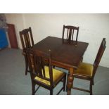 A 1920 OAK DRAW LEAF TABLE AND FOUR CHAIRS