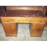 AN OAK LEATHER INLAID TWIN PEDESTAL DESK WITH INNER DRAWS