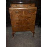 A BURR WALNUT BRITISH MADE FIVE DRAW PARTIALLY BOW FRONTED CHEST OF DRAWS WITH CABREOLE LEGS
