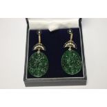 A PAIR OF OVAL SHAPED PATTERNED JADE DROP EARRINGS SET WITH DIAMONDS AND INLAID WITH BLACK ENAMEL,