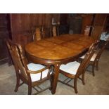 A LARGE OVAL EXTENDING DINING TABLE AND SIX CHAIRS INCLUDING TWO CARVERS