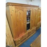 A LARGE PINE TRIPLE WARDROBE WITH CENTRAL MIRRORED DOOR AND 6 DRAWERS BELOW H 212 CMW 202 CM