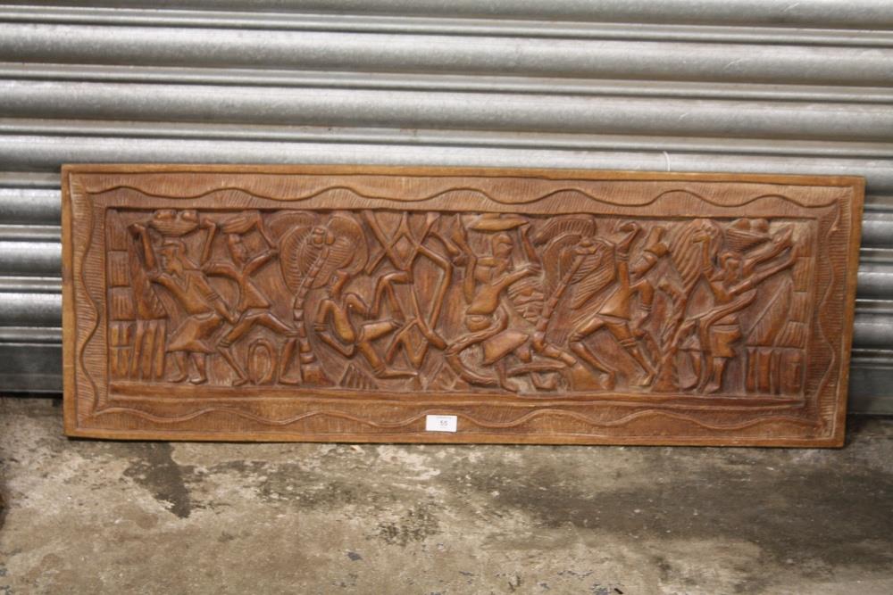 A LARGE TRIBAL STYLE CARVED HARD WOOD PANEL, 102 X 36 CM