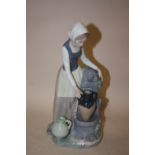 A NAO FIGURE OF A LADY COLLECTING WATER FROM THE FOUNTAIN