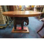 AN UNUSUAL MAHOGANY OVAL OCCASIONAL TABLE WITH A CARVED ELEPHANT SUPPORT H-58 CM W-94 CM