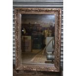 A LARGE BEVEL EDGED WALL MIRROR WITH FLORAL DETAIL TO FRAME OVERALL SIZE - 107CM X 78CM