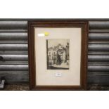 A FRAMED AND GLAZED SIGNED ETCHING DEPICTING A TOWN SCENE