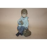 A NAO FIGURE OF A SEATED YOUNG BOY WITH A RABBIT