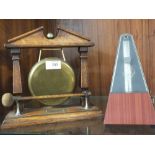 A MAHOGANY AND BRASS TABLE GONG TOGETHER WITH A METRONOME
