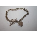 A LADIES SILVER BRACELET WITH GEM SET HEART FOB