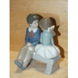 A NAO FIGURE OF A BOY AND GIRL ON A BENCH, MODEL NUMBER 1136