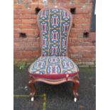 A VICTORIAN MAHOGANY FRAMED LOW NURSING CHAIR WITH TAPESTRY MATERIAL
