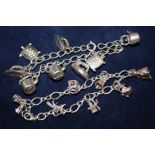 A SILVER CHARM BRACELET WITH ASSORTED CHARMS - APPROX 33.4G