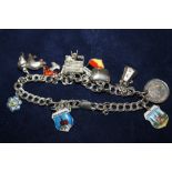 A SILVER CHARM BRACELET WITH ASSORTED CHARMS TO INCLUDE ENAMEL EXAMPLES - APPROX 19.9G