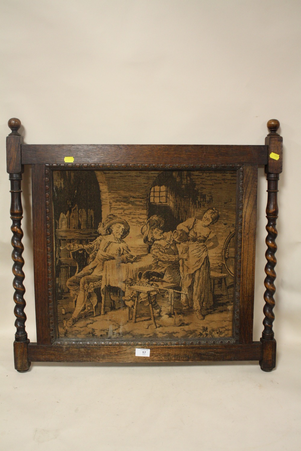 AN ANTIQUE TAPESTRY/ NEEDLEWORK PANEL DEPICTING AN INTERIOR SCENE WITH FIGURES IN OAK BARLEY TWIST