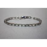 A LADIES SILVER GEM SET TENNIS BRACELET