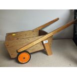 A WOODEN CHILDREN'S WHEELBARROW