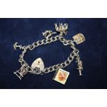 A SILVER CHARM BRACELET WITH ASSORTED CHARMS - APPROX 33.3G