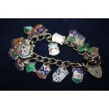 A SILVER CHARM BRACELET WITH ASSORTED CHARMS TO INCLUDE ENAMEL EXAMPLES - APPROX 42.2G