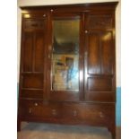 AN ANTIQUE OAK THREE DOOR MIRRORED WARDROBE