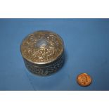 AN ANTIQUE INDIAN WHITE METAL BOX OF CIRCULAR FORM WITH PULL OFF LID