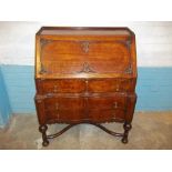 AN ANTIQUE SERPENTINE FRONTED OAK LEATHER INLAID BUREAU