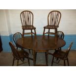 AN OAK EXTENDING DROPLEAF DINING TABLE SET WITH SIX CHAIRS