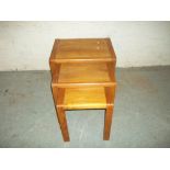 A VINTAGE TEAK NEST OF THREE TABLES