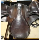 A VINTAGE ENGLISH LEATHER SADDLE WITH STIRRUPS