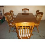 A MODERN EXTENDING WOODEN DINING SET WITH SIX CARVER CHAIRS