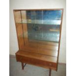 A RETRO TEAK SMALL DISPLAY MIRROR BACKED UNIT WITH GLASS SHELVES AND SLIDING GLASS DOORS MADE BY