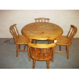 A ROUND PINE DINING SET WITH FOUR CHAIRS